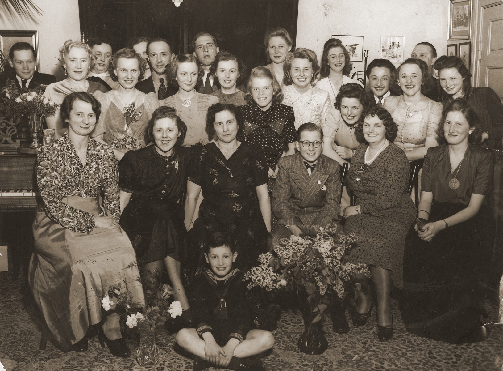 Piano students, both adults and children, pose at their piano recital.